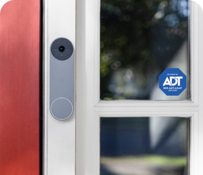 Grey Google Nest Doorbell on a frame next to an ADT window sticker