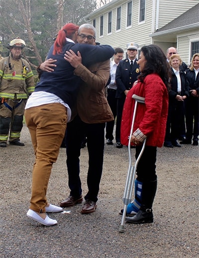 Krista Brandenburg embraces Azim and Madhavi Saifee.