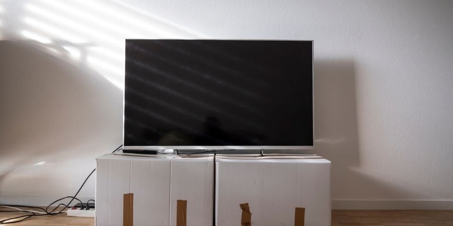 TV being packed surrounded by moving boxes