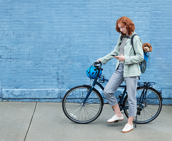 Woman riding a bike and arming her house with the ADT+ app